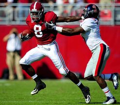 Julio Jones stiff arms an Ole Miss player as he runs with the ball